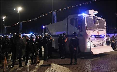 French police stand near a water cannon in Marseille's Old Port. Photo: AP