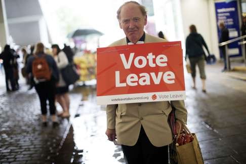 A “Vote Leave” campaigner distributes leaflets to members of the public in Manchester last Saturday. Photo: Bloomberg