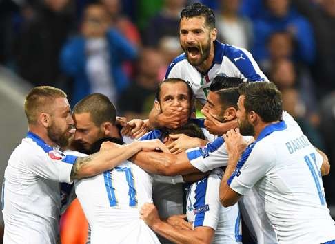 Emanuele Giaccherini (bottom C) of Italy celebrates with his teammates after scoring the opening goal. Photo: EPA