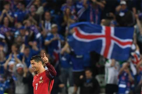 Portugal's forward Cristiano Ronaldo is frustrated as the Iceland flag flies in the background. AFP PHOTO / FRANCISCO LEONG