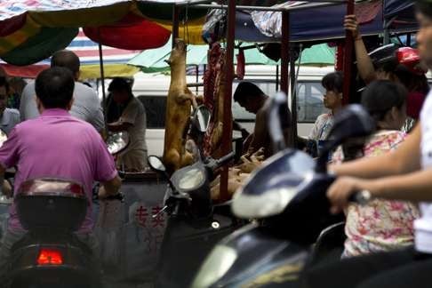 Roasted dogs hang on display for sale at a market during the annual dog-meat-eating festival in Yulin . Photo: AP