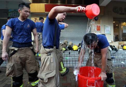 Firemen cool down during a break from tackling the blaze. Photo: Dickson Lee