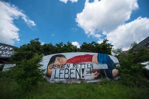 The message “Borders save lives” is written over a painting of three-year-old Aylan Kurdi in Frankfurt, western Germany, after vandals targeted the mural dedicated to the Syrian toddler who drowned last year trying to reach Europe with his family. Photo: AFP