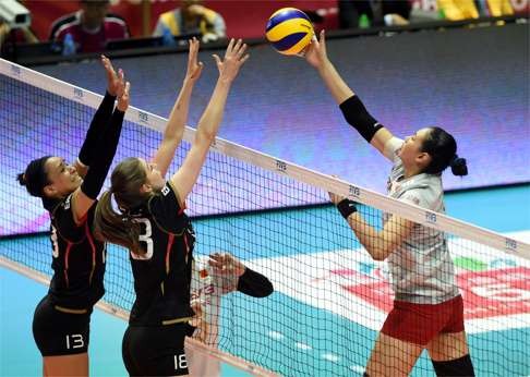 Liu Xiaotong dinks a return as Germany teammates Lisa Izquierdo (left) and Wiebke Silge try to defend the net.