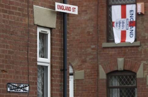 A temporary street sign hangs from a lampost on Wales Street in Oldham, northern England. Photo: Reuters