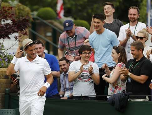 Marcus Willis dons a hat given to him by a spectator after winning his match. Photo: Reuters
