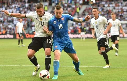 Germany forward Lukas Podolski vies with Slovakia's midfielder Juraj Kucka.