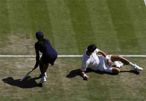 Novak Djokovic after slipping and dropping his racket. Photo: Reuters