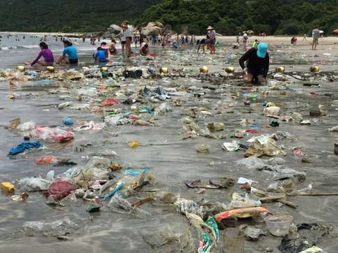 Volunteers clear trash off one of the beaches badly affected by a tide of marine refuse.