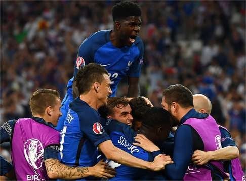 France defender Laurent Koscielny (second left) and Samuel Umtiti (top) and other teammates surround Antoine Griezmann as they celebrate his second goal. Photo: AFP