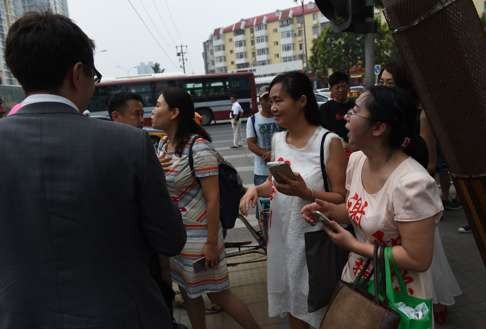 This photo taken on July 4 shows the wives of human rights lawyers detained almost a year ago wearing the names of their husbands as they meet diplomats near an office of the Supreme People's Procuratorate in Beijing. Photo: AFP