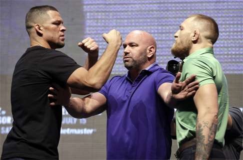Dana White (centre) stands between Nate Diaz (left) and Conor McGregor during a UFC 202 news conference on July 7. Photo: AP