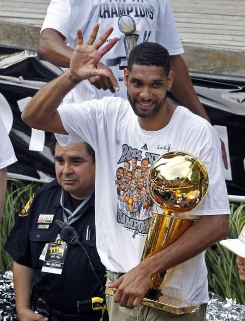In this June 18, 2014, file photo, San Antonio Spurs' Tim Duncan shows fans five fingers representing the five NBA basketball titles the Spurs and Duncan have won . (AP Photo/Michael Thomas, FIle)
