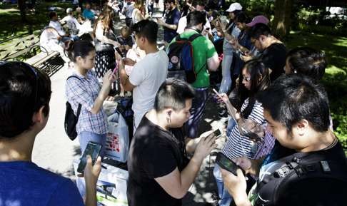 A group of people appear engrossed playing Pokemon Go on their smartphones in Union Square in New York. Photo: EPA