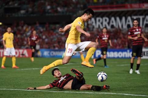 Guangzhou Evergrande's Gao Lin is tackled by Yushuke Tanaka of the Western Sydney Wanderers in March 2015. Photo: EPA