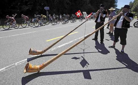 Locals play traditional Alpine horns as the Tour crosses into Switzerland. Photo: Reuters