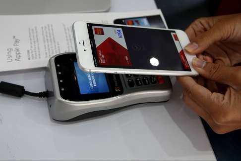 A worker demonstrates Apple Pay inside a mobile kiosk. Photo: AFP