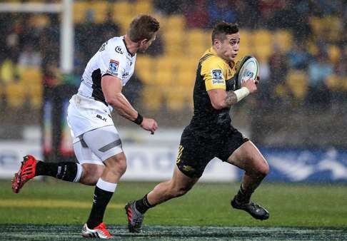 On the burst: TJ Perenara of the Hurricanes breaks away from Michael Claassens of the Sharks. Photo: AFP