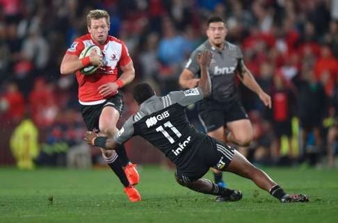 Ruan Combrinck of the Lions passing Jone Macilai of the Crusaders on his way to score a try during the Super Rugby quarter final clash between the Emirates Lions and the Crusaders at Ellis Park rugby stadium in Johannesburg on July 23, 2016. / AFP PHOTO / Christian KOTZE