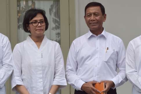 Security Minister Wiranto (R) and Finance Minister Sri Mulyani (L) pose together as President Joko Widodo (unseen) announces new cabinet ministers. Photo: AF