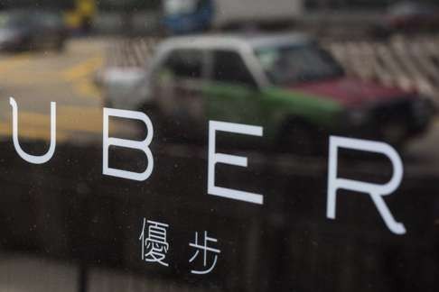 A taxi is reflected in a window at the office of taxi-hailing service Uber in Hong Kong on August 12, 2015. Photo: Reuters