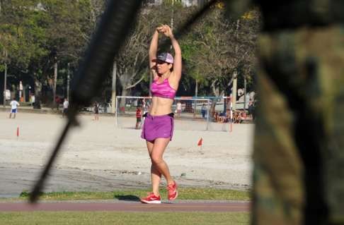 A woman exercises as a marine stands guard at Flamengo Park in Rio. Photo: AFP