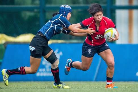Hong Kong captain Lee Tsz-ting fends off her Japan defender during the 2015 Asia Rugby U-20 Sevens Series. Photo: HKRU