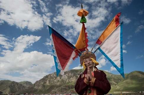 A Tibetan Buddhist monk with an elaborate headdress poses for a photo at the festival in Yushu. Photo: AFP