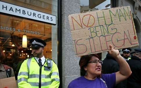 Protestors hold a demonstration outside a Byron restaurant in Holborn, central London, after arrest of dozens of staff by immigration officials reportedly tipped off by the management. Photo: AFP