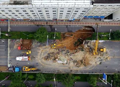 Rescue workers are continuing to search for the two people who fell into the sinkhole in the Chinese city of Zhengzhou据on Monday night. Photo: SCMP Pictures