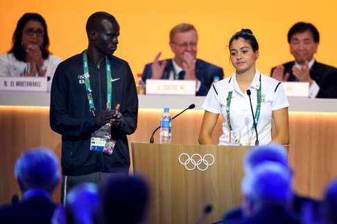 Team member of the Refugee Olympic Athletes, South Soudan's Yiech Pur Biel (2nd L) and Syria's Yusra Mardini (2rd R) are welcomed by International Olympic Committee (IOC) members during the 129th International Olympic Committee session, in Rio de Janeiro on August 2, 2016, ahead of the Rio 2016 Olympic Games. / AFP PHOTO / FABRICE COFFRINI