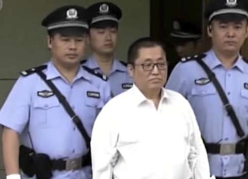Zhai Yanmin is escorted by court police as he arrives at the hearing in Tianjin. Photo: CCTV
