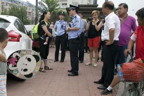 Yuan Shanshan (left), the wife of detained lawyer Xie Yanyi, is questioned by police near the Tianjin court on Tuesday. Photo: AP