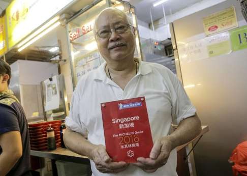 Tang Chay Seng, the owner of Hill Street Tai Hwa Pork Noodle, poses with his Michelin Award in front of his store in Singapore. Photo: EPA