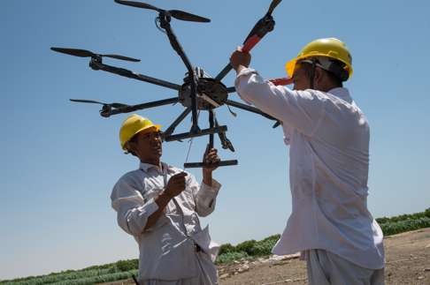 Workers from China Electric Power Equipment and Technology Co prepare a drone for stringing the wire between power grid towers across the Nile River in Egypt. Photo: Xinhua