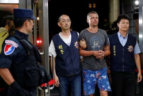 Latvian suspect Andrejs Peregudovs is brought to Taipei police station on July 17. Photo: Reuters