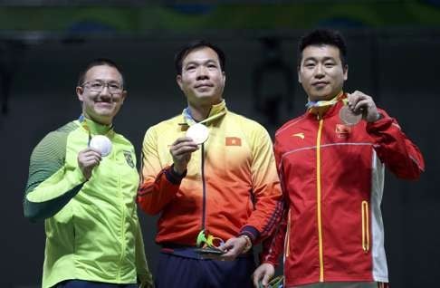 Felipe Wu (L) of Brazil, Hoang Xuan Vinh (C) of Vietnam and Pang Wei (R) of China pose with their medals. Photo: Reuters