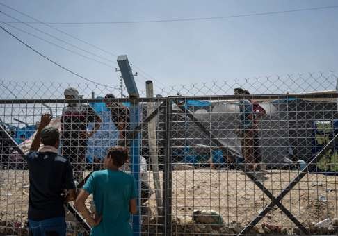 Men speak through a fence surrounding an area where newcomers are interrogated at Dibaga camp for internally displaced civilians in Iraq. Photo: AP