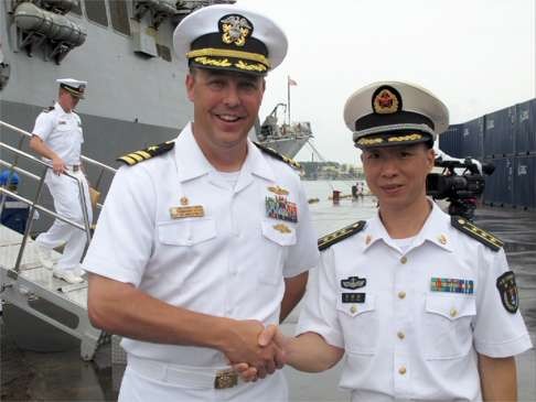 US Navy Commander Justin L. Harts ( left) shakes hands with Chinese PLA Navy officer Liu Huimin, Photo: AP