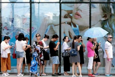People queue outside a newly opened duty free shop in Shanghai. The central government is pushing domestic consumption and recovery. Photo: China Daily/Reuters