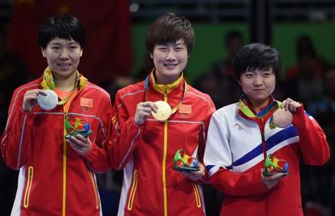 Gold medalist Ding Ning (C) of China, with silver medalist Li Xiaoxia (L) and bronze medalist I Song Kim (R) of North Korea. Photo: EPA