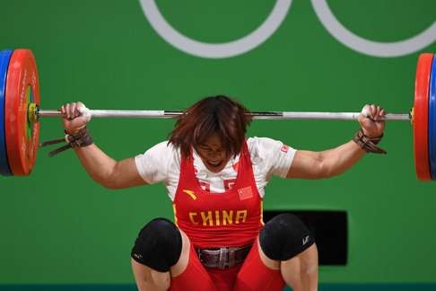 Xiang Yanmei hits her head while competing in the women’s 69kg weightlifting competition. Photo: AFP