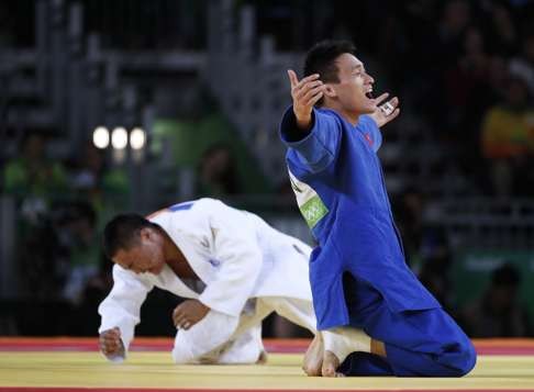 Xunzhao Cheng celebrates after beating Otgonbaatar Lkhagvasuren of Mongolia in the men’s 90kg bronze medal bout. Photo: EPA