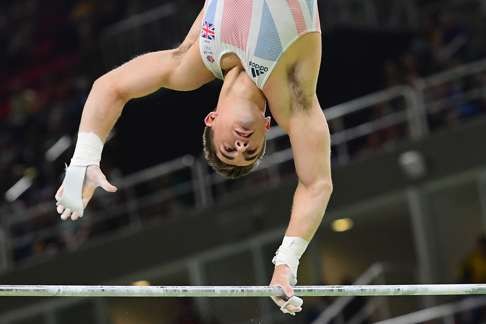 Whitlock competes in the horizontal bar event of the men’s individual all-around final. Photo: AFP