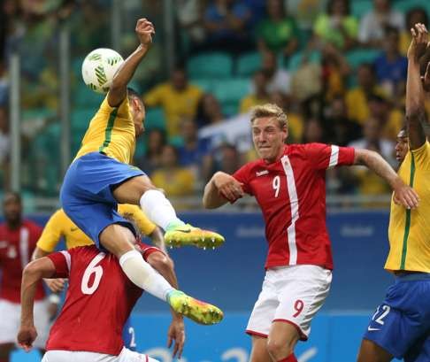 Brazil’s Marquinhos challenges for a ball with Denmark’s Andres Maxso and Nicolai Brock-Madsen during their group A match. Photo: AP