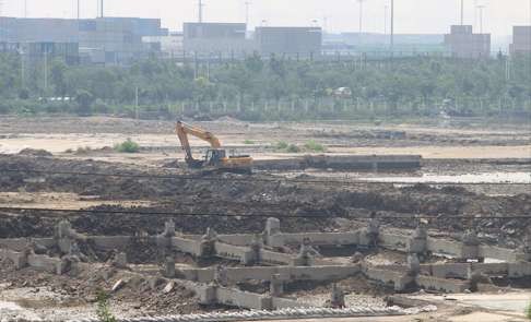 Workers fill up the pit caused by last year's explosion in Tianjin. Photo: SCMP Pictures