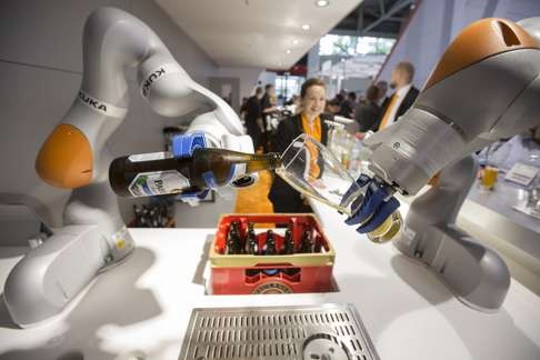 A Kuka LBR iiwa industrial robotic arm pours a glass of weiss beer during a display on the Kuka AG exhibition. Midea on Monday announced it was buying more than 94 per cent of Kuka AG. Photo: Bloomberg