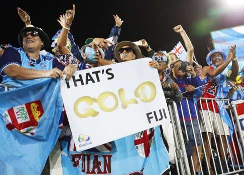 Fans for the Fijian sevens team celebrate their gold medal win. Photo: Kyodo