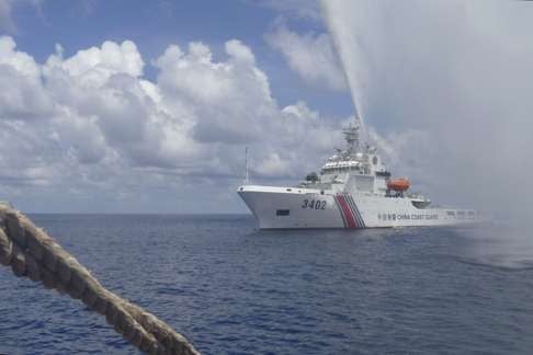 A Chinese coastguard boat sprays a water cannon at Philippine fishermen near Scarborough Shoal in the South China Sea in this photo from September last year provided by one of the fishermen. Photo: AP