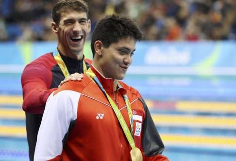 Joseph Schooling gets a pat on the back from Michael Phelps as they leave the medals podium. Photo: Reuters